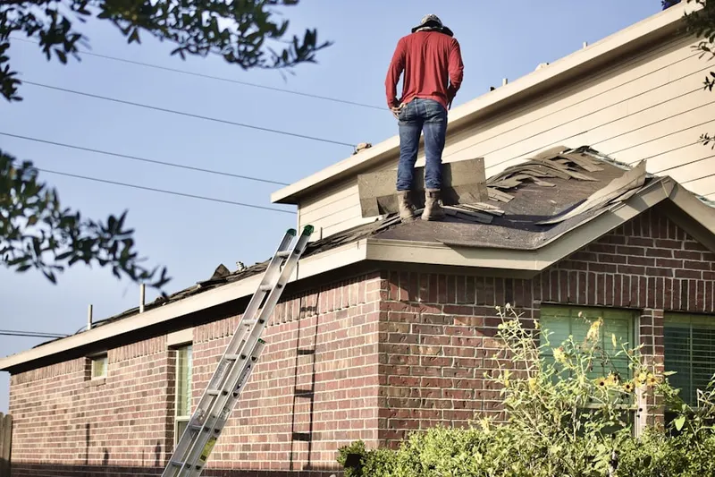 Professional roofer working on a residential roof in Burton